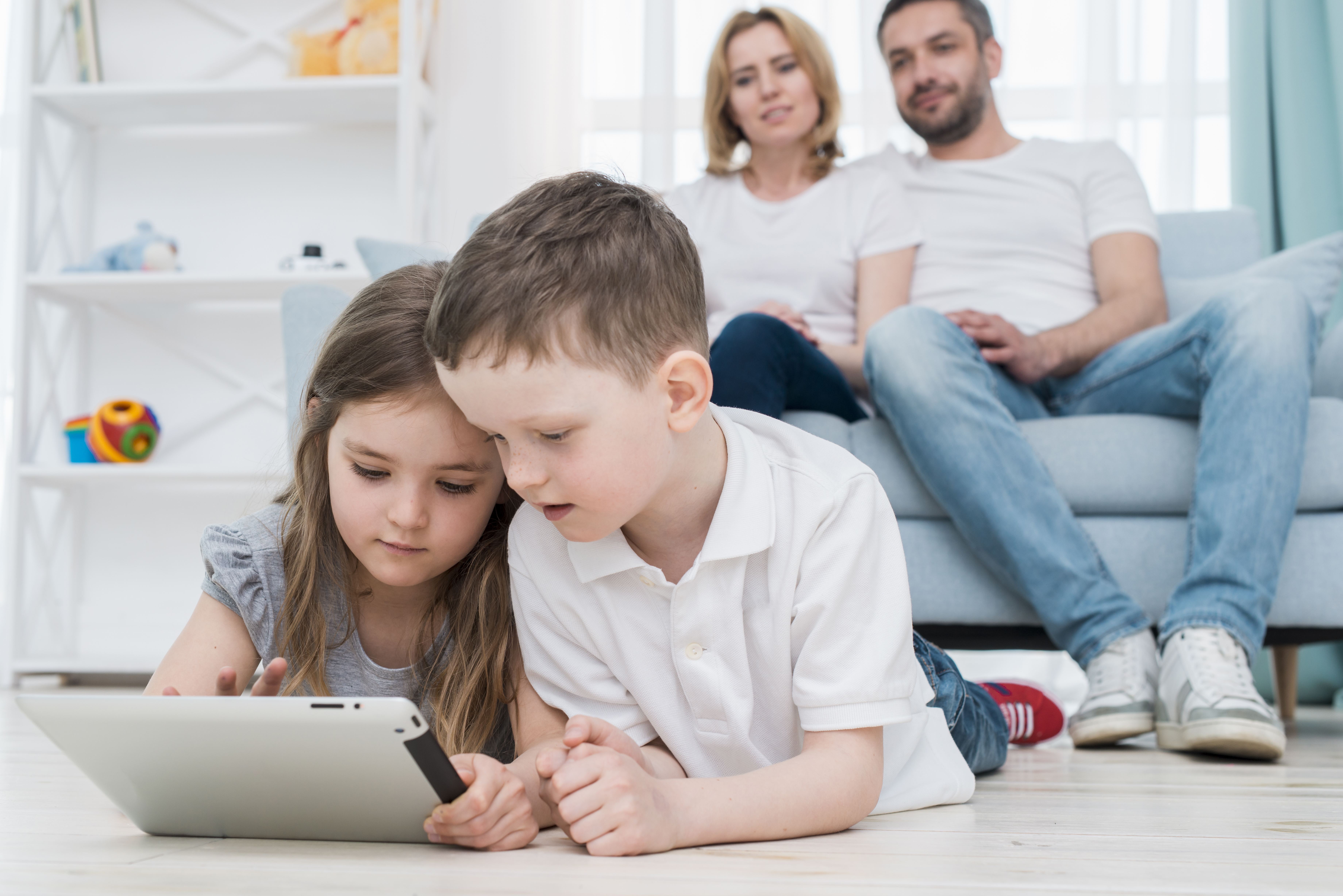 kids using tablet and parents watching them