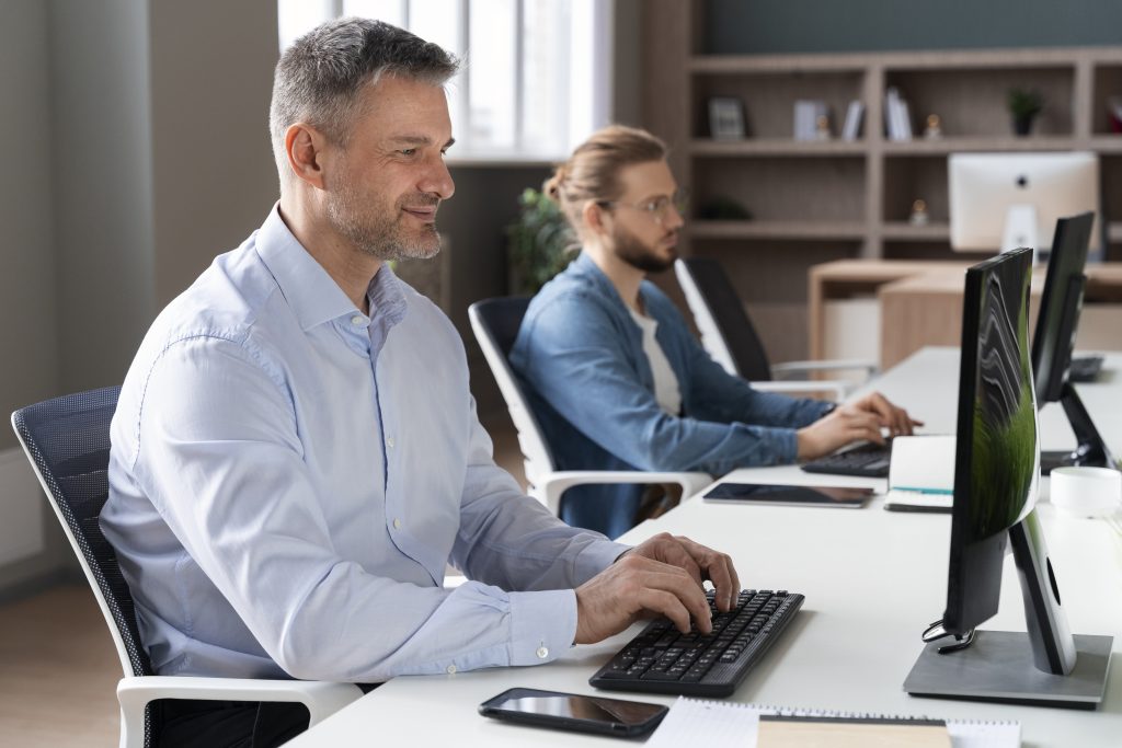 Business professionals working in a modern office environment with focus on IT operations, cybersecurity governance, and team collaboration